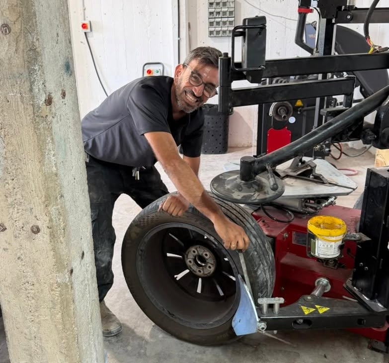 איתי מתקין צמיג בפנצ'ריה ברמת דוד